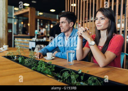 Happy young couple in restaurant waiting for food and talking Stock Photo