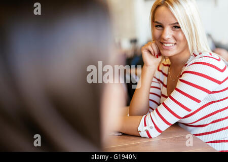Beautiful women in cafe talking and gossiping Stock Photo