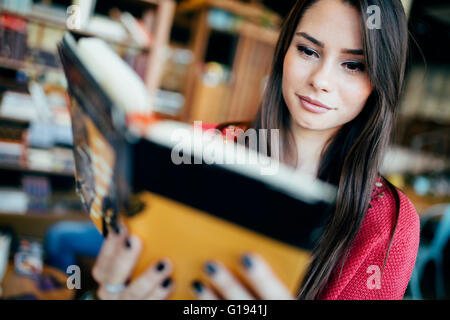 Beautiful woman reading book and preparing for exam Stock Photo
