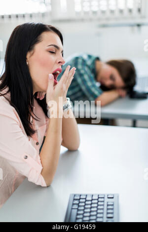 Young beautiful girl yawning during class from boredom and fatigue Stock Photo