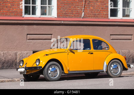 Helsinki, Finland - May 7, 2016: Old yellow Volkswagen beetle is parked on a roadside Stock Photo