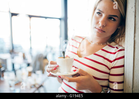 Portrait of a beautiful woman drinking coffee, tea in a cafe Stock Photo