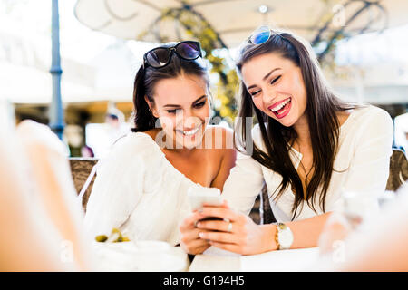Two young girls talking and smiling during lunch break Stock Photo