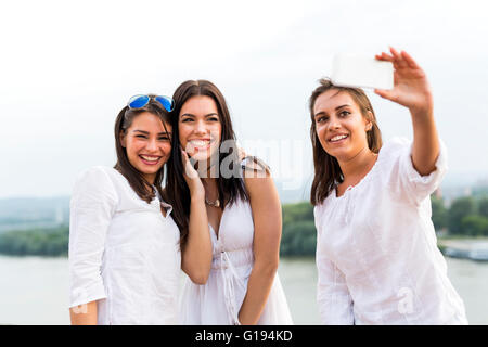 Three happy women taking a selfie of themselves and playing around Stock Photo