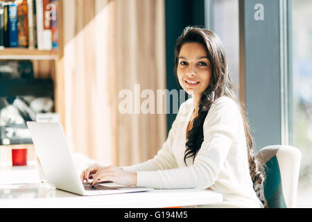 Beautiful brunette using notebook in cafe Stock Photo