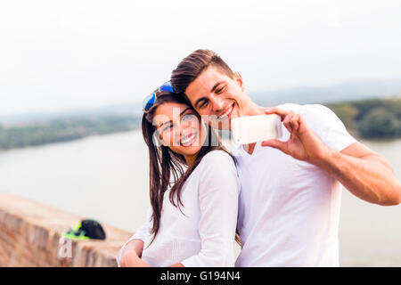 Young beautiful couple taking a selfie of themselves and being happy