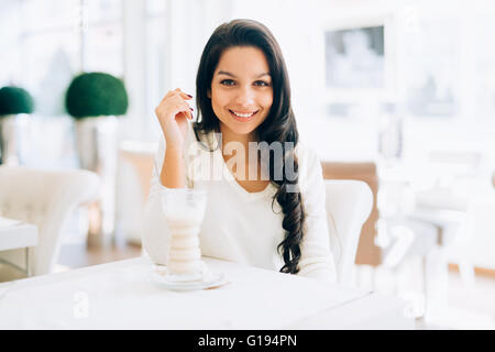 Beautiful woman drinking coffee in cafe Stock Photo