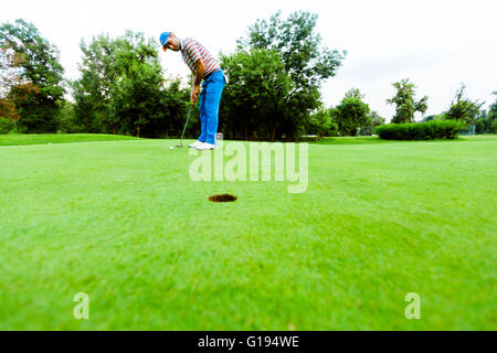 Golfer ready to take the shot on the putting green Stock Photo