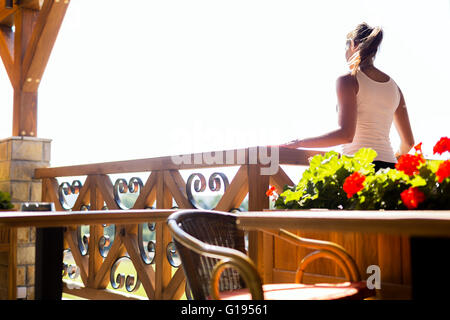 Beautiful woman enjoying the view from the terrace on warm summer day Stock Photo