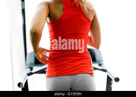Running motion of a young woman running on a treadmill in a gym Stock Photo