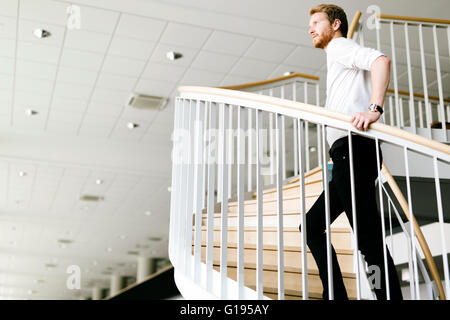 Business visionary represented by a man climbing stairs and thinking Stock Photo