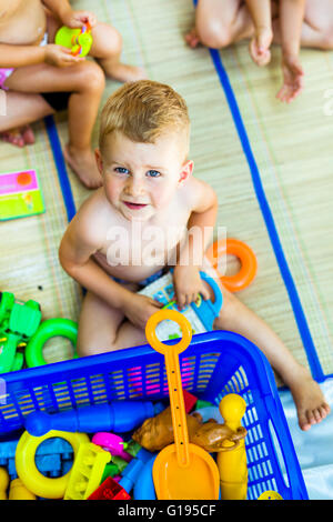 Beautiful young children playing with plastic toys outdoor Stock Photo