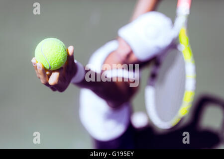 Beautiful female tennis player serving outdoor and a closeup of the serve from above Stock Photo