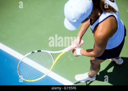 Beautiful female tennis player serving outdoor and a closeup of the serve from above Stock Photo