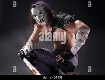 Costumed hero as a street maniac with a bat. Casey Jones on black background. Stock Photo