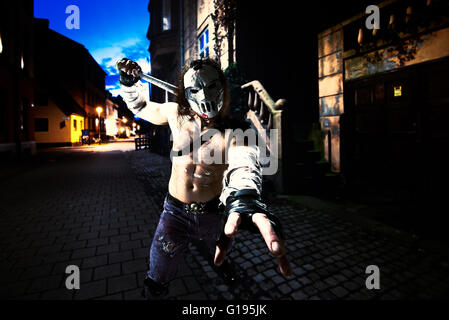 Costumed hero as a street maniac with a bat. Casey Jones on Malmo street. Combined image - studio work was added to real landsca Stock Photo