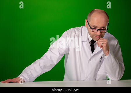 a white man in a white lab coat, glasses, on a green background Stock Photo