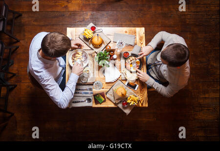 Young men having lunch at a cafe, view from above Stock Photo