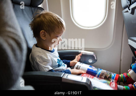 Little boy reading magazine on airplane Stock Photo