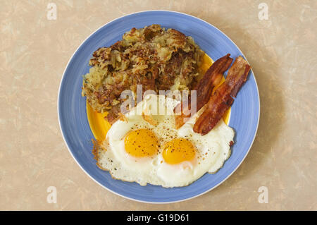 hearty breakfast plate with hash browns two eggs and bacon Stock Photo