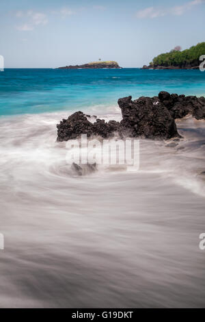 Incoming tide and turquoise coloured sea at a Bali beach captured using a slow shutter speed Stock Photo
