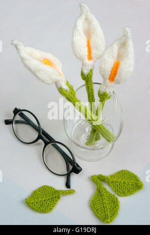 Romantic desk with ornament from handmade product, lily flower knit from white yarn,  glasses, beautiful craft Stock Photo