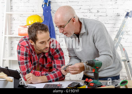 two technician examining a mechanical part in the workshop Stock Photo