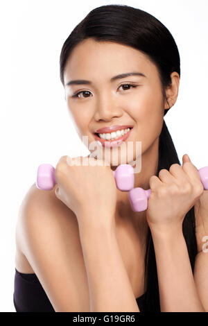 Attractive Asian woman working out with weights Stock Photo