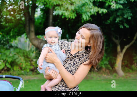 Smiling mother and baby playing in park Stock Photo