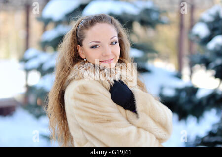 A Girl Wearing Warm Winter Clothes And Hat Blowing Snow In Winte Stock Photo