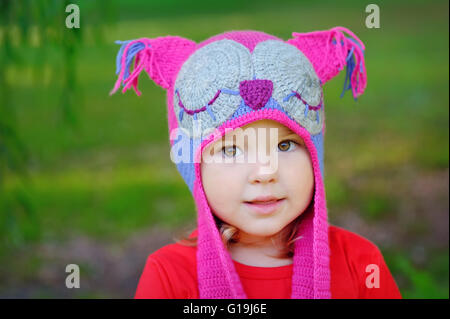 Portrait of adorable toddler girl with curly blond hair in fur w Stock Photo