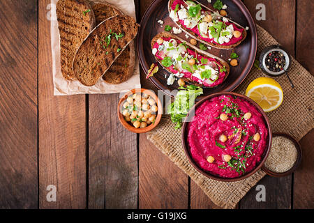 Vegan sandwiches with beetroot hummus, cucumber and blue cheese. Top view Stock Photo