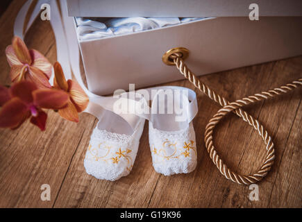 pair of baby shoes sitting on baby blanket with copy space Stock Photo