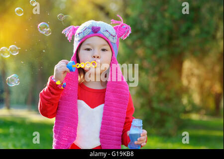 little girl blowing soap bubbles, closeup portrait. Stock Photo