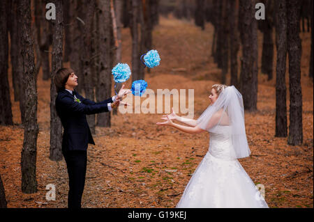 bride and groom playing in the woods Stock Photo