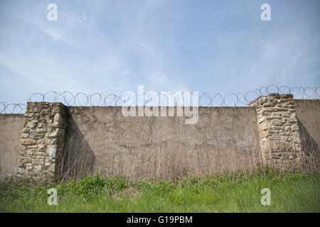 Prison wall with barbed wire Stock Photo