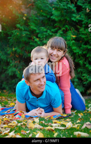 happy family in autumn park on a green lawn Stock Photo