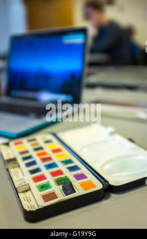 A-Level art lesson at a UK comprehensive school with a palette of paints and a macbook laptop in the background Stock Photo