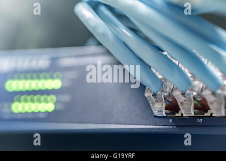 Gigabit switch with connected cables inside server rack Stock Photo