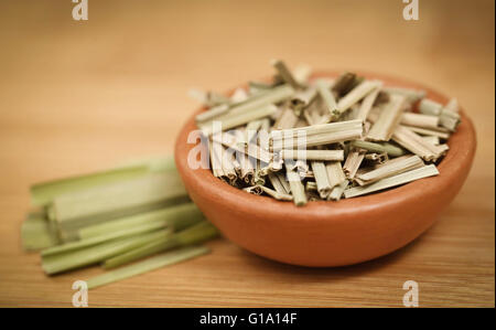 Lemongrass in a bowl on wooden surface