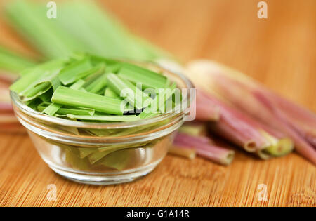 Lemongrass in a bowl on wooden surface Stock Photo