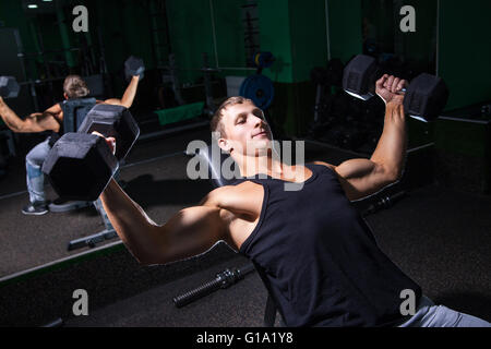 Handsome sportsman doing bench press exercise Stock Photo