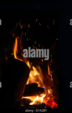 Crest of flame on burning wood in fireplace close up Stock Photo