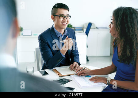 Smiling young businessman consulting clients Stock Photo