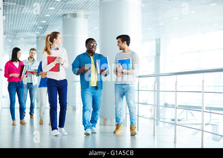 Group of college students talking in corridor after classes Stock Photo