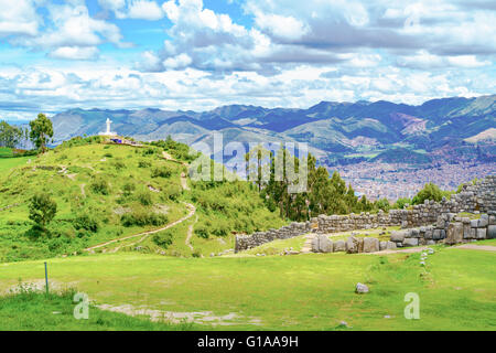 Lanscape of Saqsaywaman with the statue of Jesus Christ and aerial view of City of Cusco in Peru Stock Photo