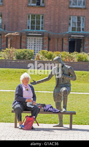 Lady sat by statue outside the Royal Shakespeare Theatre, Stratford upon Avon, Warwickshire, England, UK Stock Photo