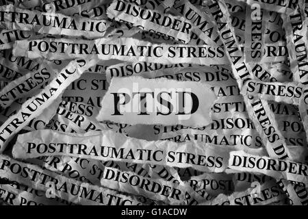 Torn pieces of paper with abbreviate PTSD. Posttraumatic stress disorder. Concept Image. Closeup. Stock Photo