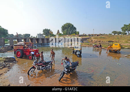 Local people clean their vehicles in a river, Khajuraho, Madhya Pradesh, India Stock Photo