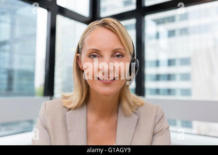 Smiling Businesswoman in the office on video conference, headset, point of view Stock Photo